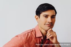 Headshot of curious Hispanic male looking at camera in grey studio, copy space 4jqzW5