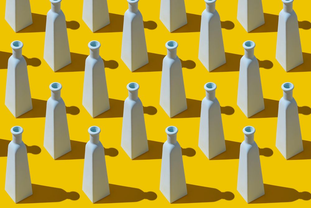 Painted glass bottles on yellow background