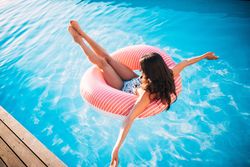Woman floats in a swimming pool in an inflatable ring