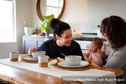 Happy women with baby at their dining table bYBnd0