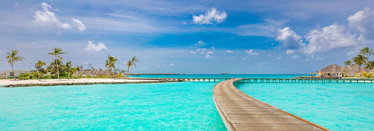 Pathway over the water leading to beach at a holiday resort, wide