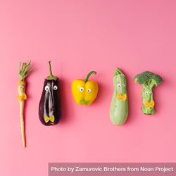 Various vegetables with googly eyes and bow tie pasta on pink background 0PgMNb