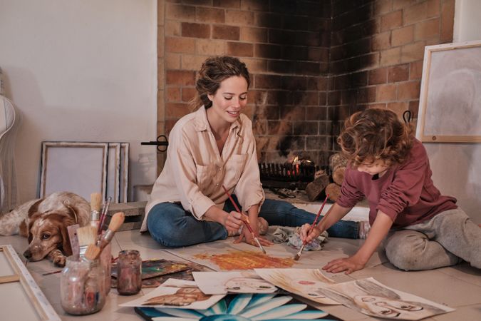Woman and child with brushes painting together