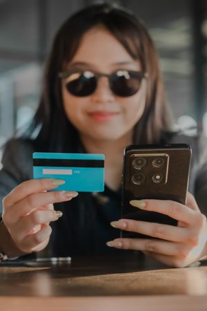 Effortless purchasing: woman utilizing credit card and mobile ph