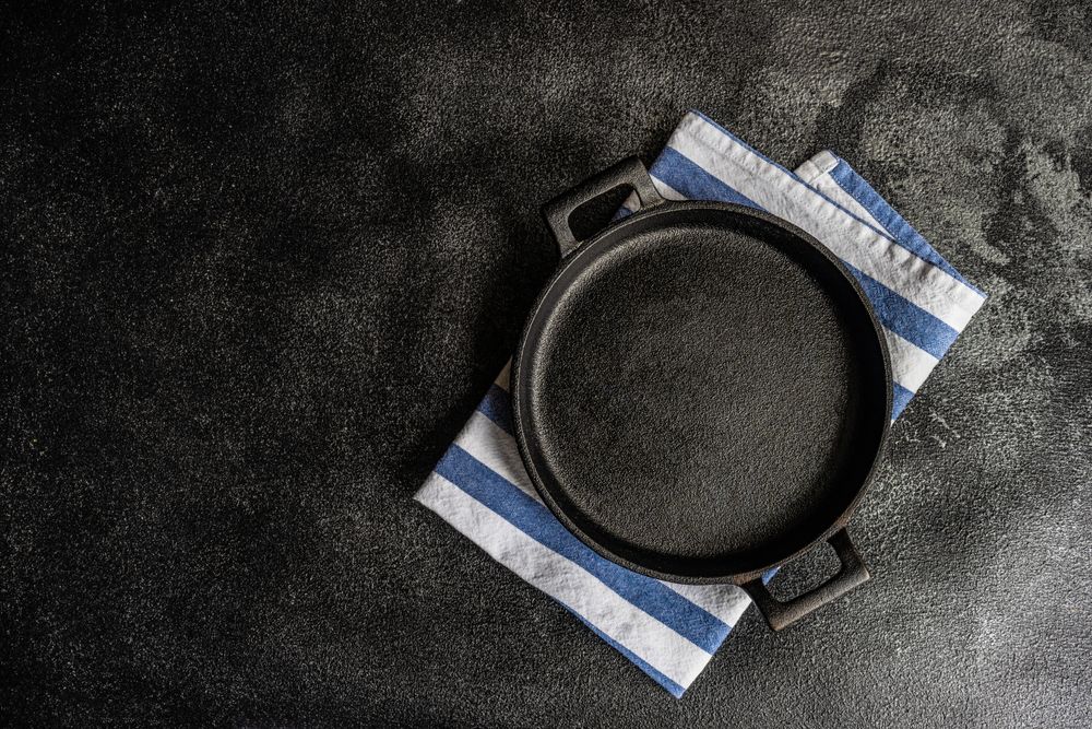 Empty pan on striped napkin as a table setting concept with space for text