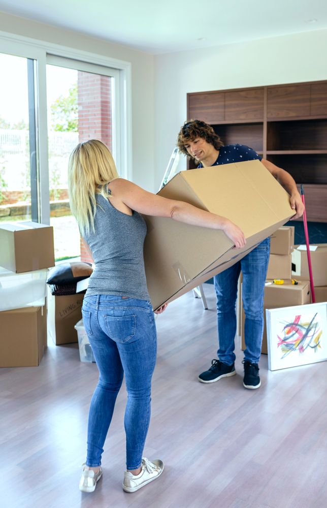 Couple carrying big moving box