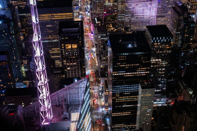 Helicopter Tour of New York City Architecture at Night. Fly-By Over Manhattan with Panorama of Office Buildings with Lights and Congested Streets with Cars and Taxi Vehicles