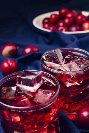 Red beverage near fresh fruits on cloth