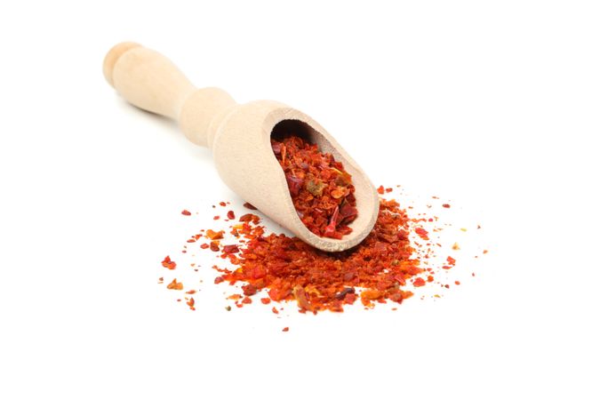 Wooden scoop with pepper spice isolated on blank background