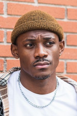 Stylish Black man against brick wall