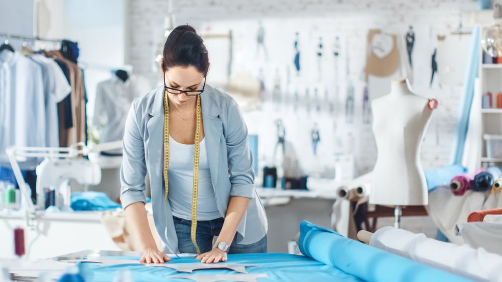 Female fashion, designer,  Draws on a Piece of Fabrics.
