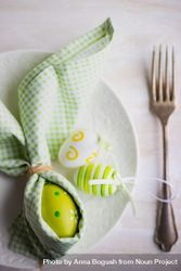 Easter holiday concept of green Easter egg wrapped like rabbit with napkin 5RVVNr