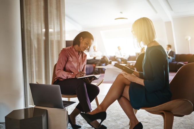 Two business women working together and taking notes