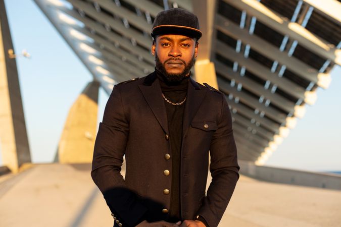 Portrait of stylish Black man standing outdoors in a sunny day