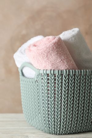 Basket with clean laundry on wooden board, space for text
