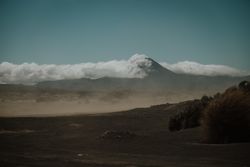 Dusty valley against high mountains in clouds