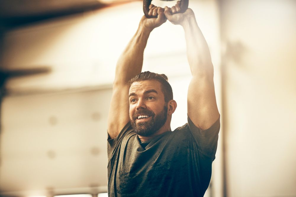 Happy man mid kettlebell workout