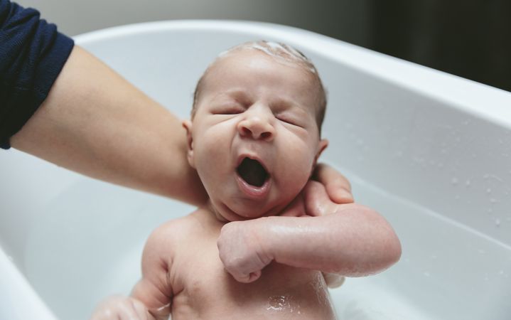 Newborn yawning in the bathtub