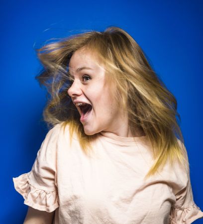 Excited young woman shaking hair