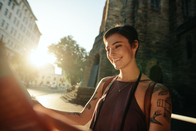 Woman tourist using a map to explore the city with sun flare
