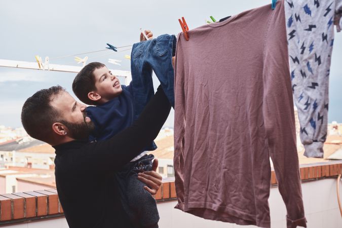 Father and son hanging clothes on rope