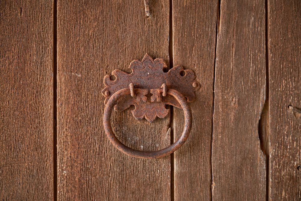 Metal old handle on wooden door