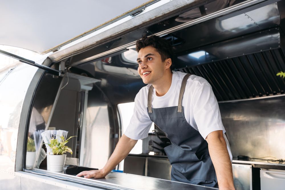 Food truck cook smiling in van kitchen