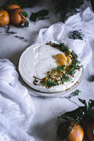 Tangerine cake decorated with whipped cream and sliced citrus