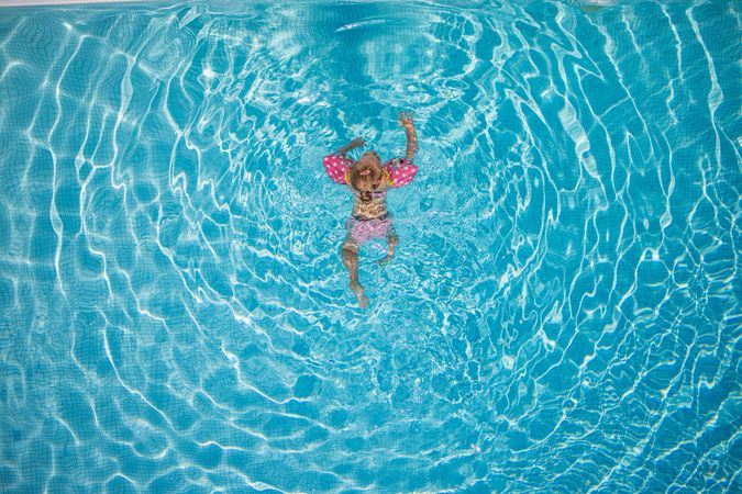 Girl in water wings swimming