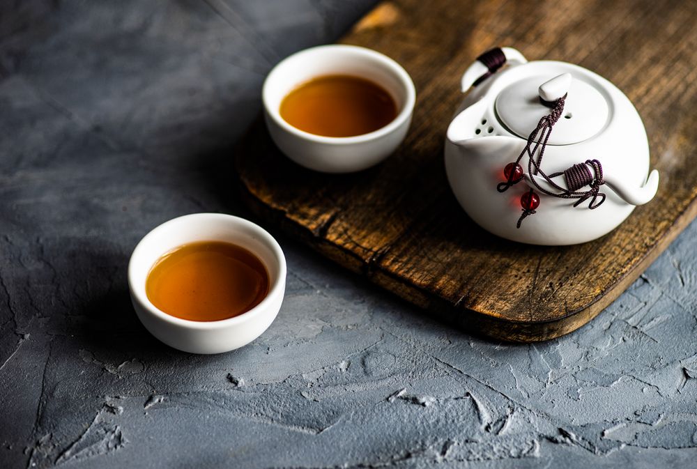 Teapot and two cups on grey counter with copy space