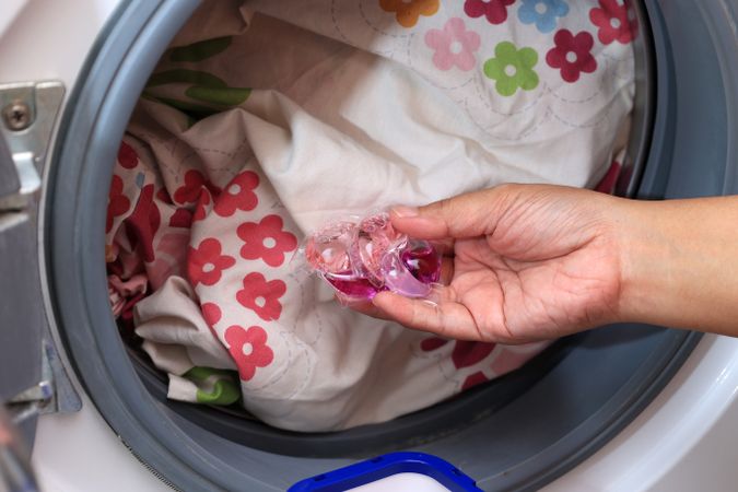 Woman Hand Hold Laundry Pod Gel.
