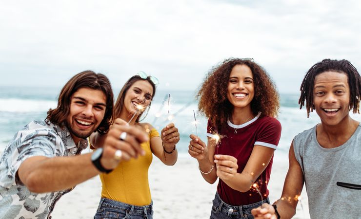Diverse group of young people celebrating new year's at the beach