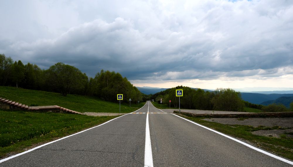 Mountain road and cloudy sky.