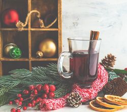 Christmas mulled wine surrounded by woolen scarf and branch