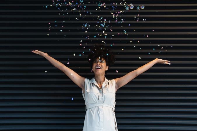 Happy Black pregnant woman throwing confetti