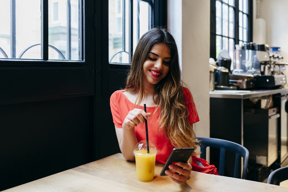 Woman sipping smoothie in cafe