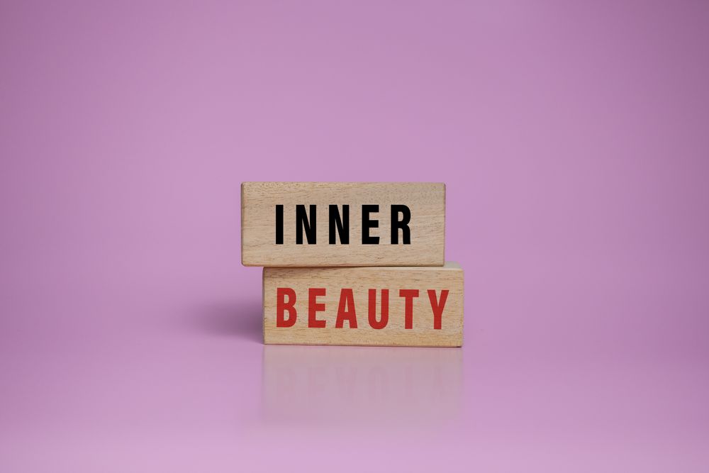inner beauty words on wooden blocks isolated on pink background