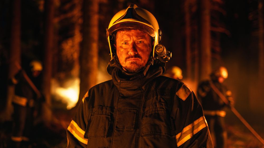 Portrait of a Confident Serious White Firefighter in Professional Protective Uniform and Helmet Looking at Camera and Posing.
