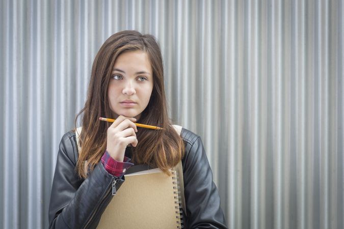 Young Melancholy Female Student With Books Looking to the Side