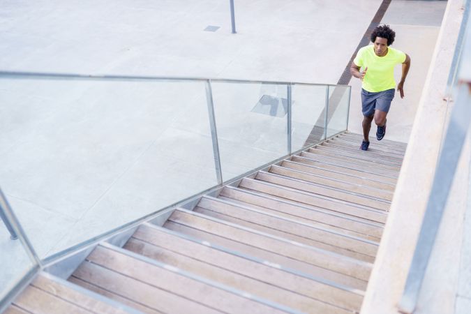 Fit man in neon T-shirt approaching steps to sprint up