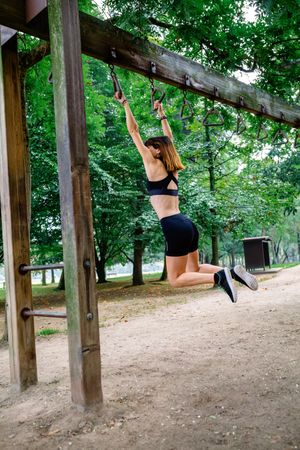 Woman doing monkey exercises on rings