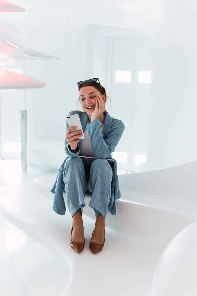 Positive woman browsing smartphone in studio