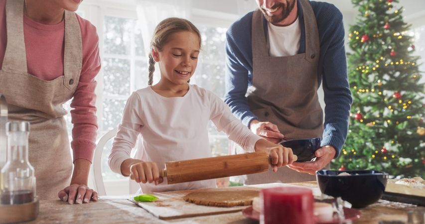 Cute Little Girl and Parents Making Gingerbread Cookies.