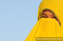 Close-up of girl in yellow Hijab covering her face 5k6LD0
