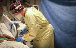Shiprock, NM - USA, Dec. 31, 2020: Nurse in scrubs and PPE checking blood sugar level of patient