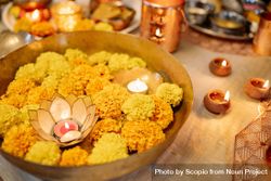Bowl of marigold flowers with candle and diyas bGXov0