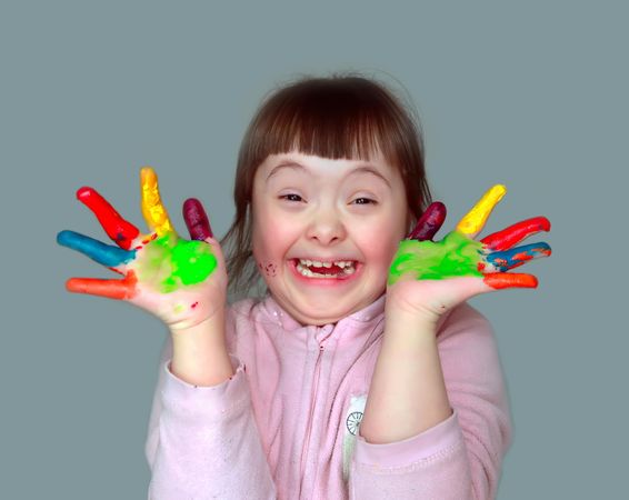 Adorable little girl finger painting with bright colors