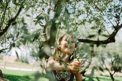 Smiling girl climbing tree in sunny day