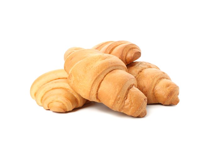 Side view of stacked croissants isolated on plain background
