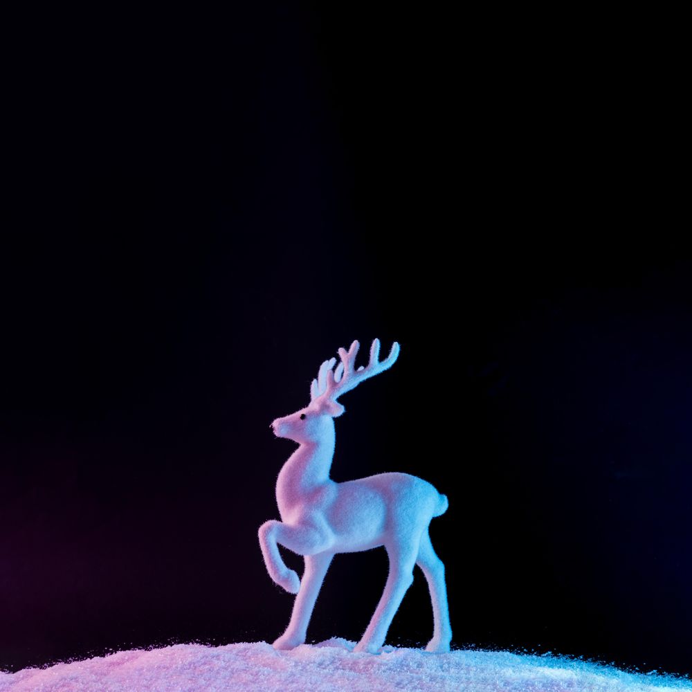 Reindeer on vibrant bold gradient holographic colors on snow